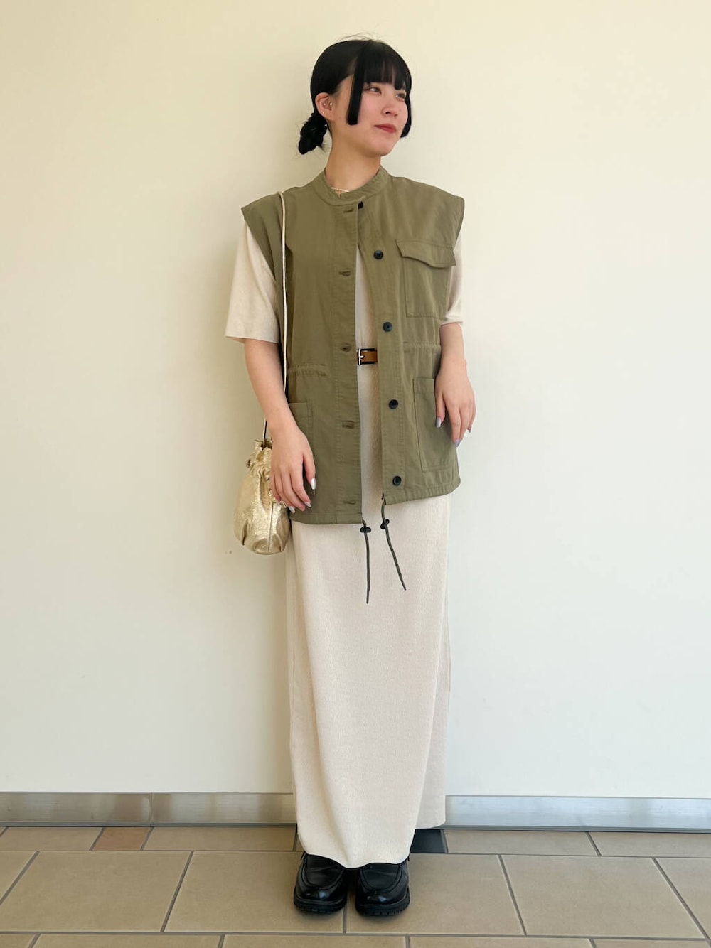 ゴールド系のショルダーバッグ、ホワイト系のワンピース、グリーン系のその他アウターを着用したレディースの春コーディネートの1枚目の写真