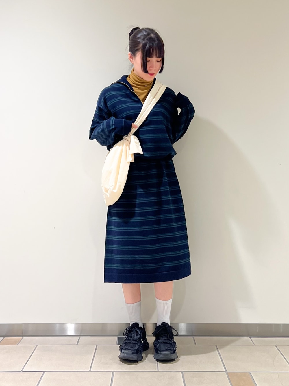 ブルー系のワンピース、イエロー系のTシャツ/カットソー、ホワイト系のショルダーバッグを着用したレディースの秋コーディネートの1枚目の写真