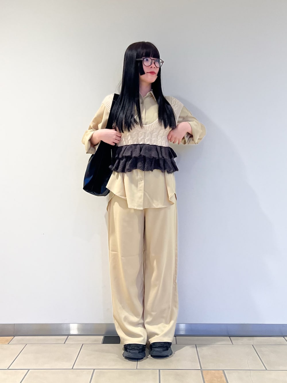 ベージュ系のニット/セーター、ベージュ系のセットアップ、グレー系のメガネを着用したレディースの春コーディネートの1枚目の写真