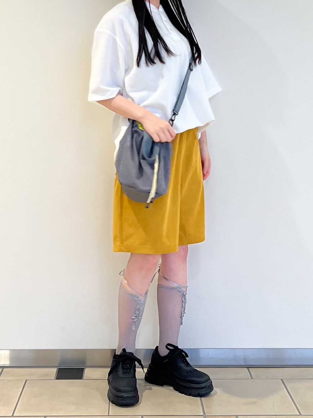 イエロー系のその他パンツ、ホワイト系のTシャツ/カットソー、ブラック系のスニーカーを着用したレディースの春コーディネートの1枚目の写真