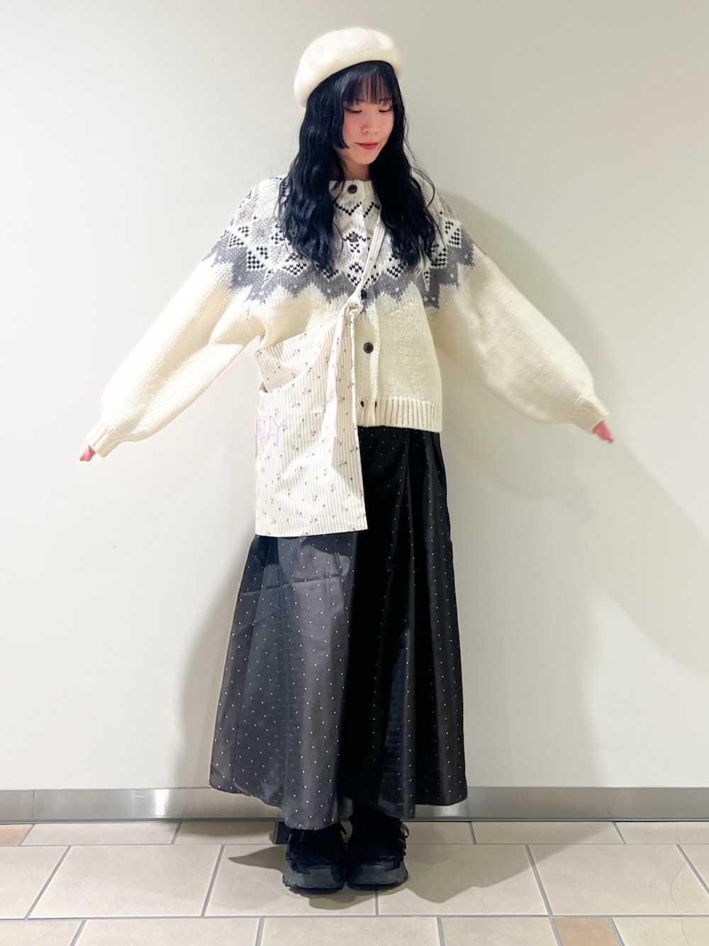 ホワイト系のカーディガン/ボレロ、ベージュ系のショルダーバッグ、ブラウン系のスカートを着用したレディースの冬コーディネートの1枚目の写真