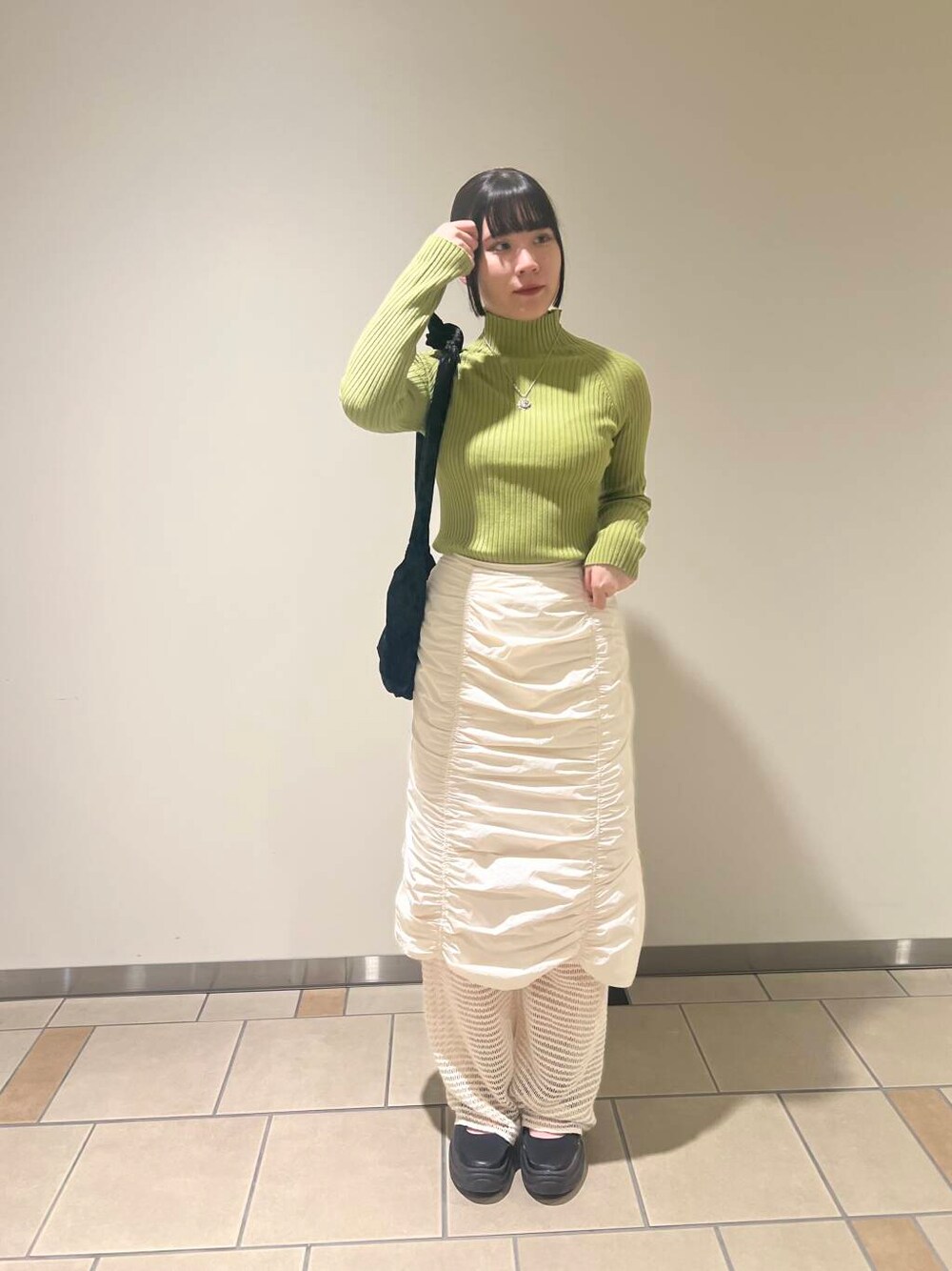 グリーン系のニット/セーター、ホワイト系のその他パンツ、ブラック系のハンドバッグを着用したレディースの秋コーディネートの1枚目の写真