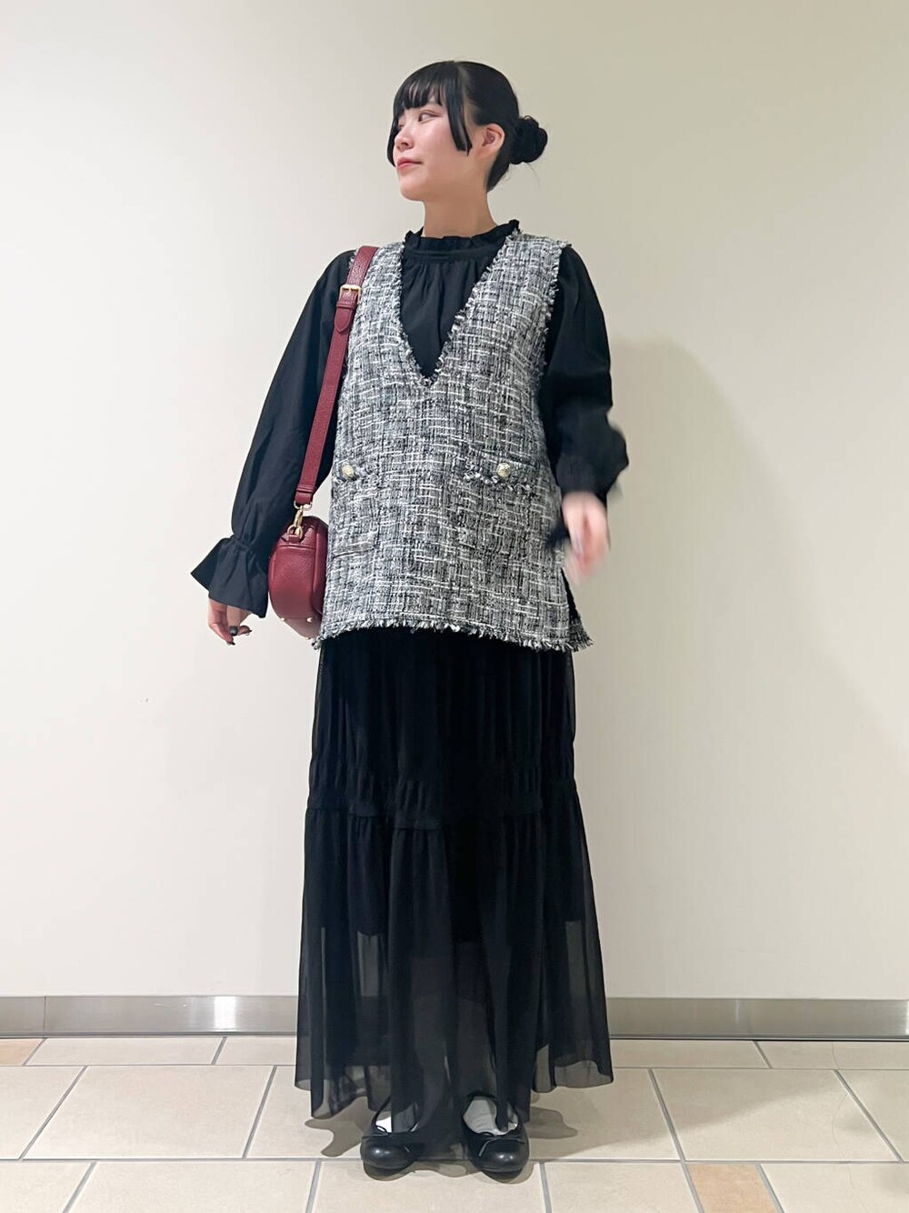 ブラック系のバレエシューズ、レッド系のショルダーバッグ、ブラック系のベストを着用したレディースの春コーディネートの1枚目の写真
