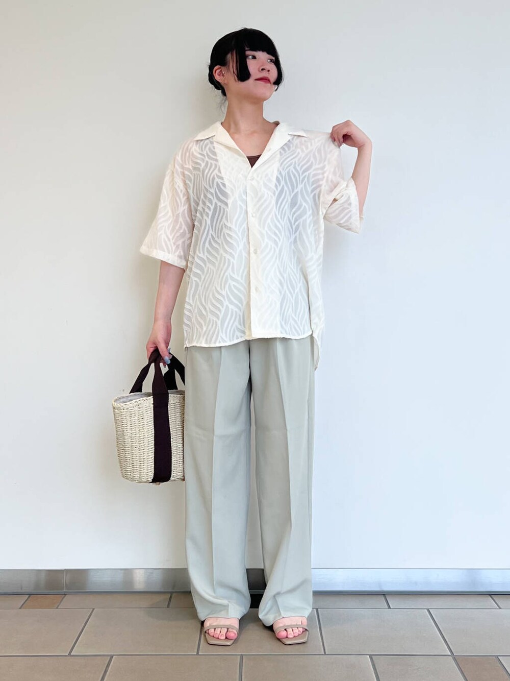 グレー系のサンダル、ホワイト系のハンドバッグ、ブラウン系のタンクトップを着用したレディースの夏コーディネートの1枚目の写真