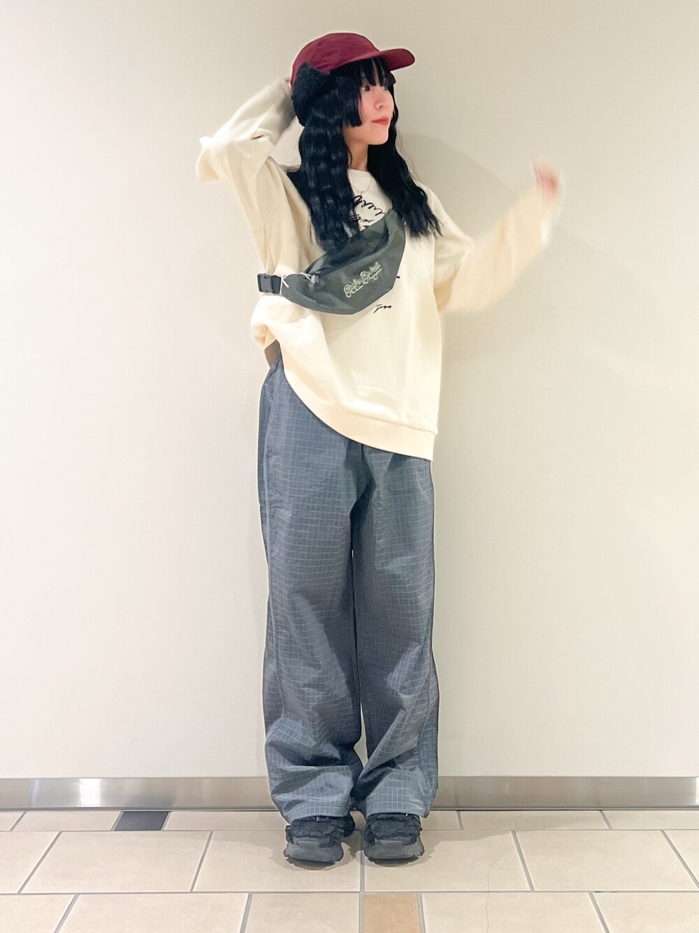 グレー系のその他パンツ、ホワイト系のスウェット、レッド系のキャップを着用したレディースの秋コーディネートの1枚目の写真