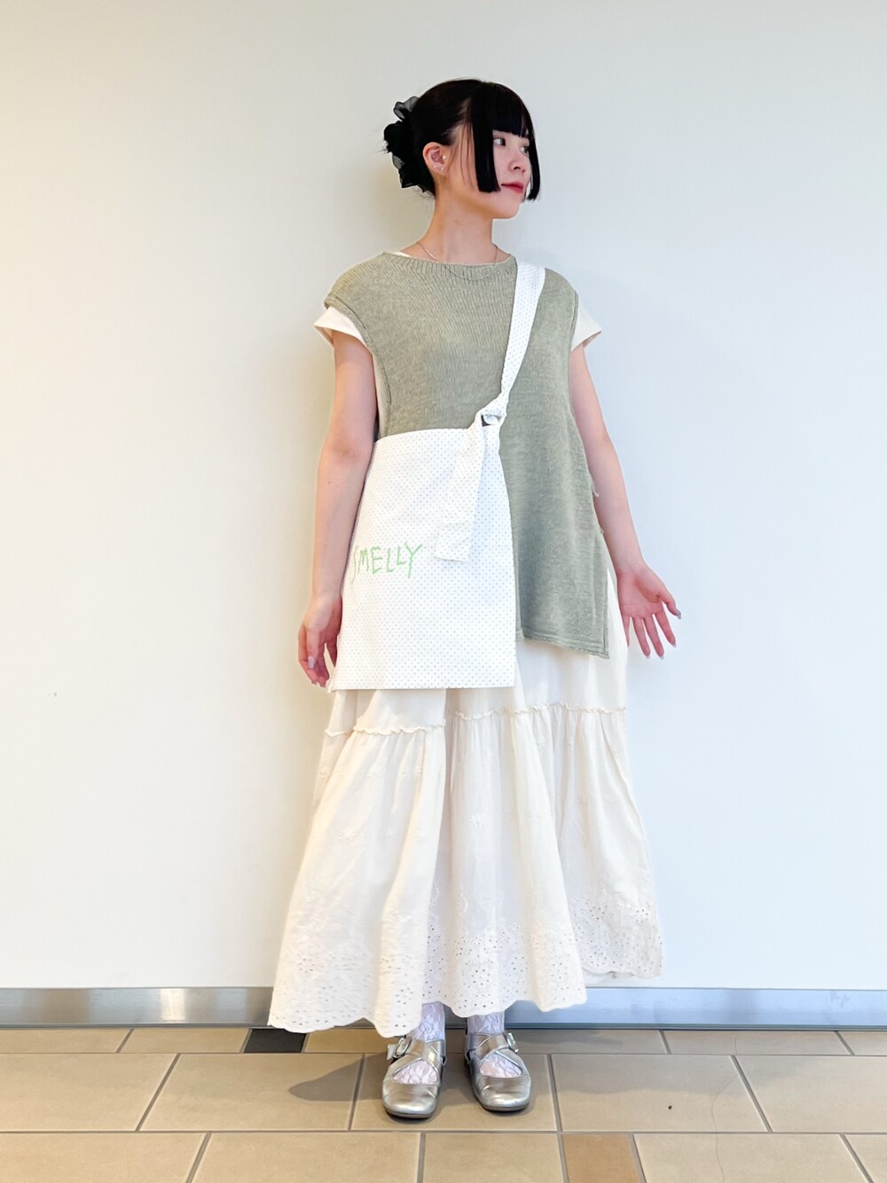 グリーン系のベスト、ホワイト系のワンピースを着用したレディースの夏コーディネートの1枚目の写真
