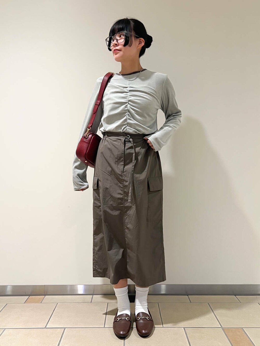 ブラウン系のローファー、レッド系のショルダーバッグ、ベージュ系のTシャツ/カットソーを着用したレディースの春コーディネートの1枚目の写真