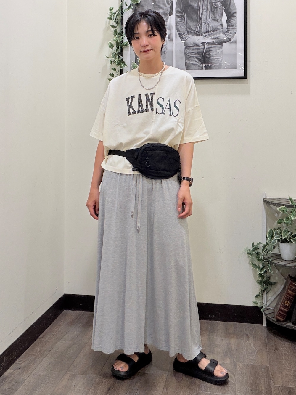 ホワイト系のTシャツ/カットソー、グレー系のスカート、ブラック系のサンダルを着用したレディースの夏コーディネートの1枚目の写真