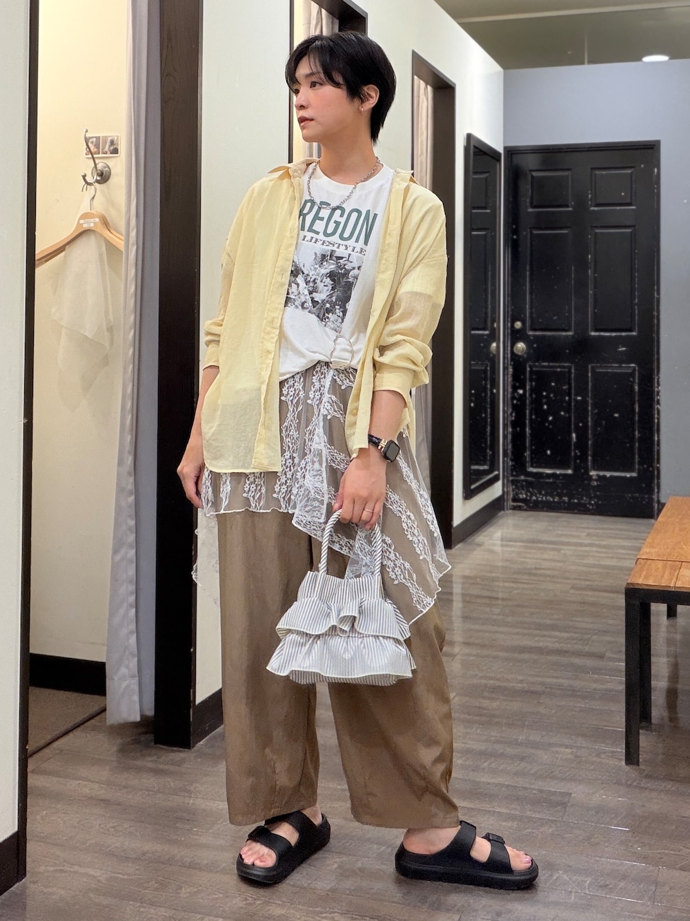 イエロー系のシャツ/ブラウス、ブラウン系のその他パンツ、ブラック系のサンダルを着用したレディースの夏コーディネートの1枚目の写真