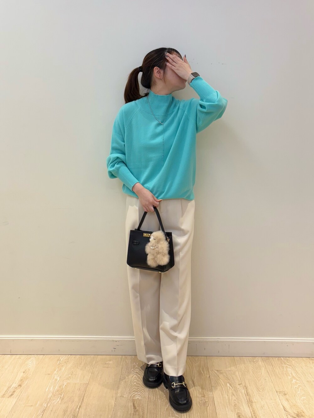 ブラック系のショルダーバッグ、ホワイト系のその他パンツ、グリーン系のニット/セーターを着用したレディースの秋コーディネートの1枚目の写真