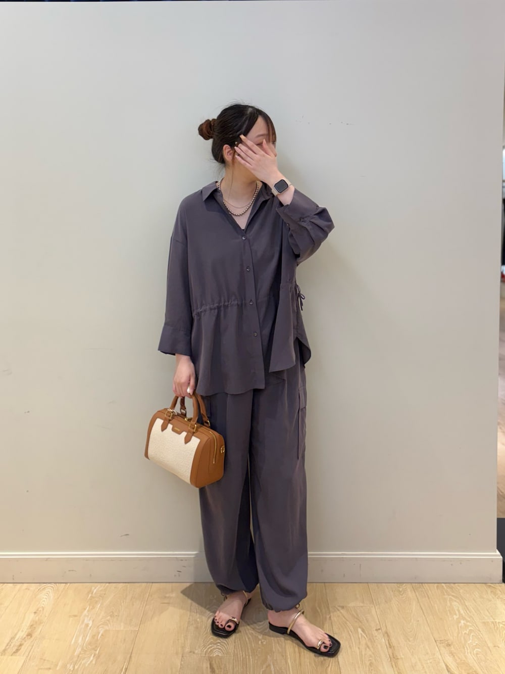 ブラウン系のボストンバッグ、グレー系のカーゴパンツ、グレー系のシャツ/ブラウスを着用したレディースの春コーディネートの1枚目の写真