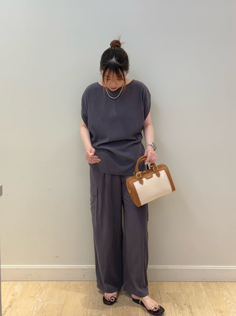 グレー系のシャツ/ブラウス、グレー系のカーゴパンツ、ブラウン系のボストンバッグを着用したレディースの春コーディネートの1枚目の写真