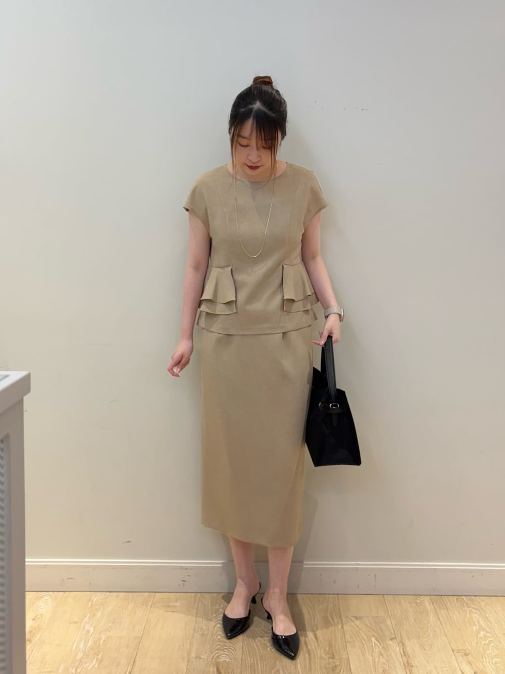 ブラック系のトートバッグ、ベージュ系のシャツ/ブラウス、ベージュ系のスカートを着用したレディースの春コーディネートの1枚目の写真