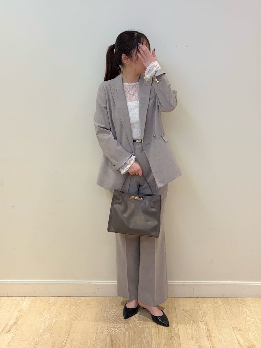 ベージュ系のトートバッグ、グレー系のテーラードジャケット、ブラック系のTシャツ/カットソーを着用したレディースの春コーディネートの1枚目の写真