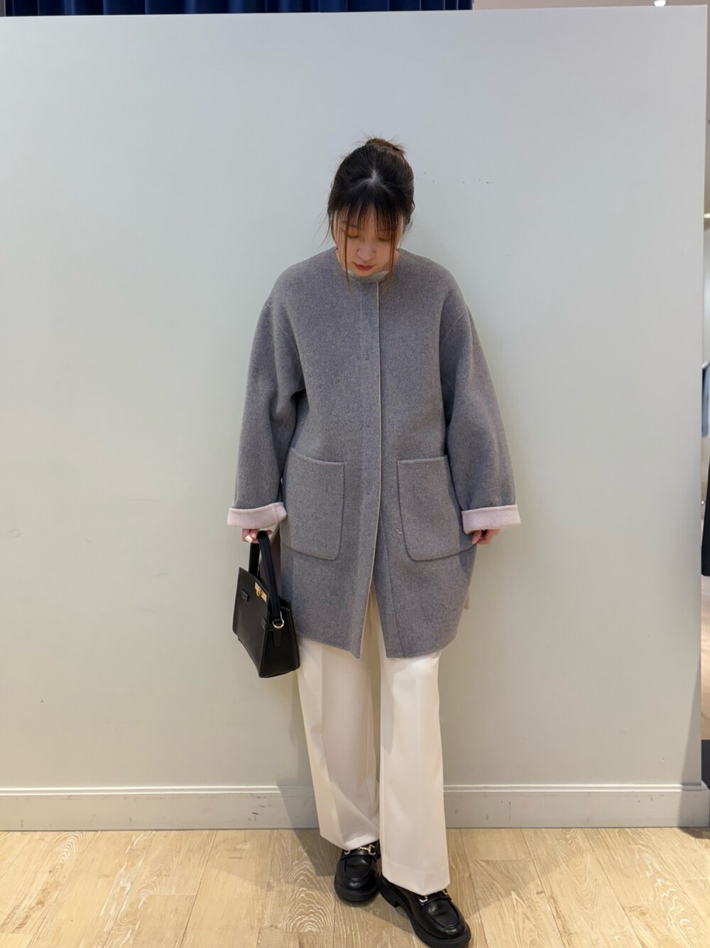 ベージュ系のニット/セーター、ホワイト系のその他パンツ、ブラック系のショルダーバッグを着用したレディースの冬コーディネートの1枚目の写真