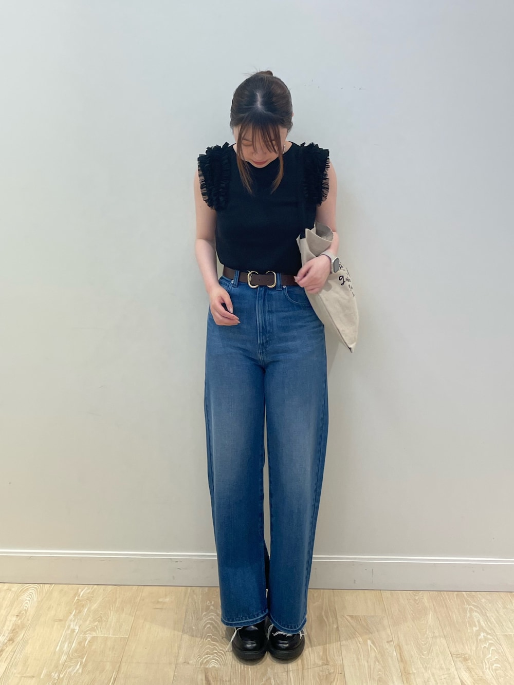 ブラック系のバックパック/リュック、ブルー系のデニムパンツ、ブラック系のニット/セーターを着用したレディースの夏コーディネートの1枚目の写真