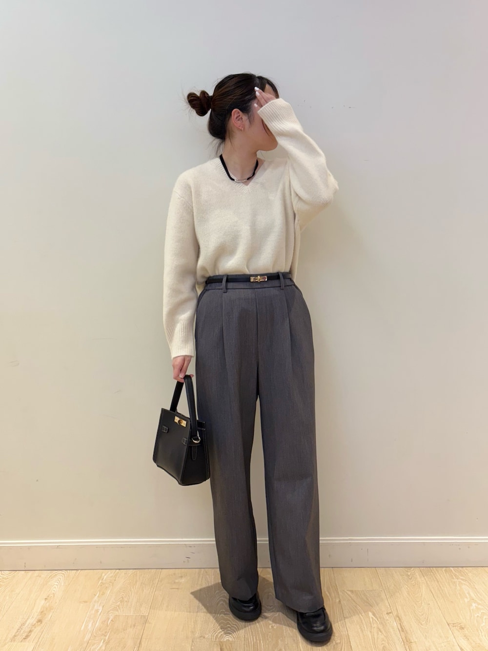 ブラック系のショルダーバッグ、ホワイト系のニット/セーター、グレー系のその他パンツを着用したレディースの秋コーディネートの1枚目の写真