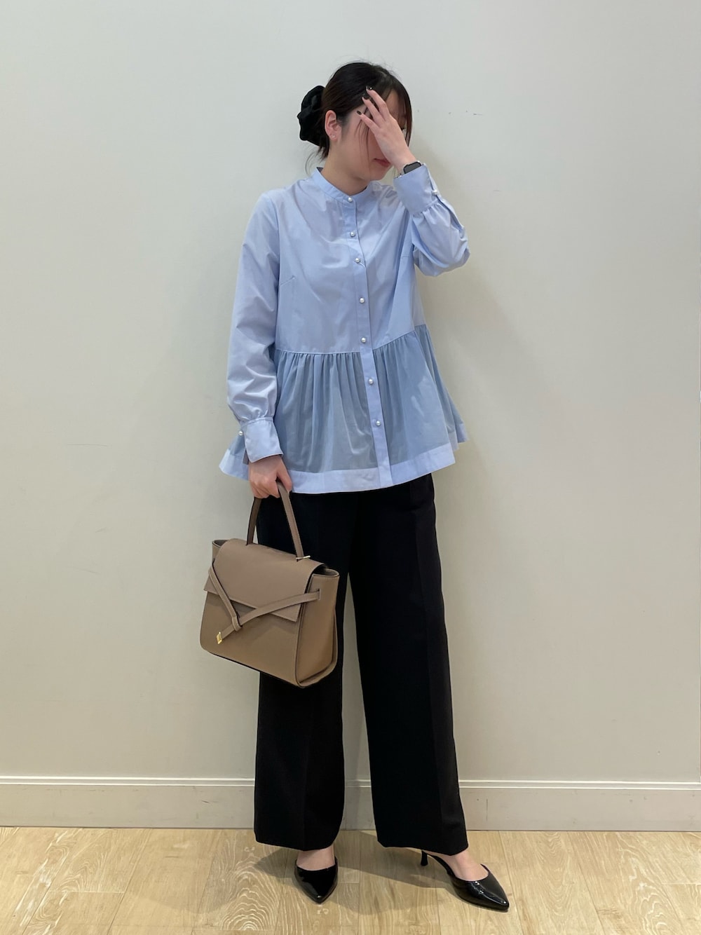 ブルー系のシャツ/ブラウス、ブラック系のその他パンツ、ベージュ系のショルダーバッグを着用したレディースの冬コーディネートの1枚目の写真