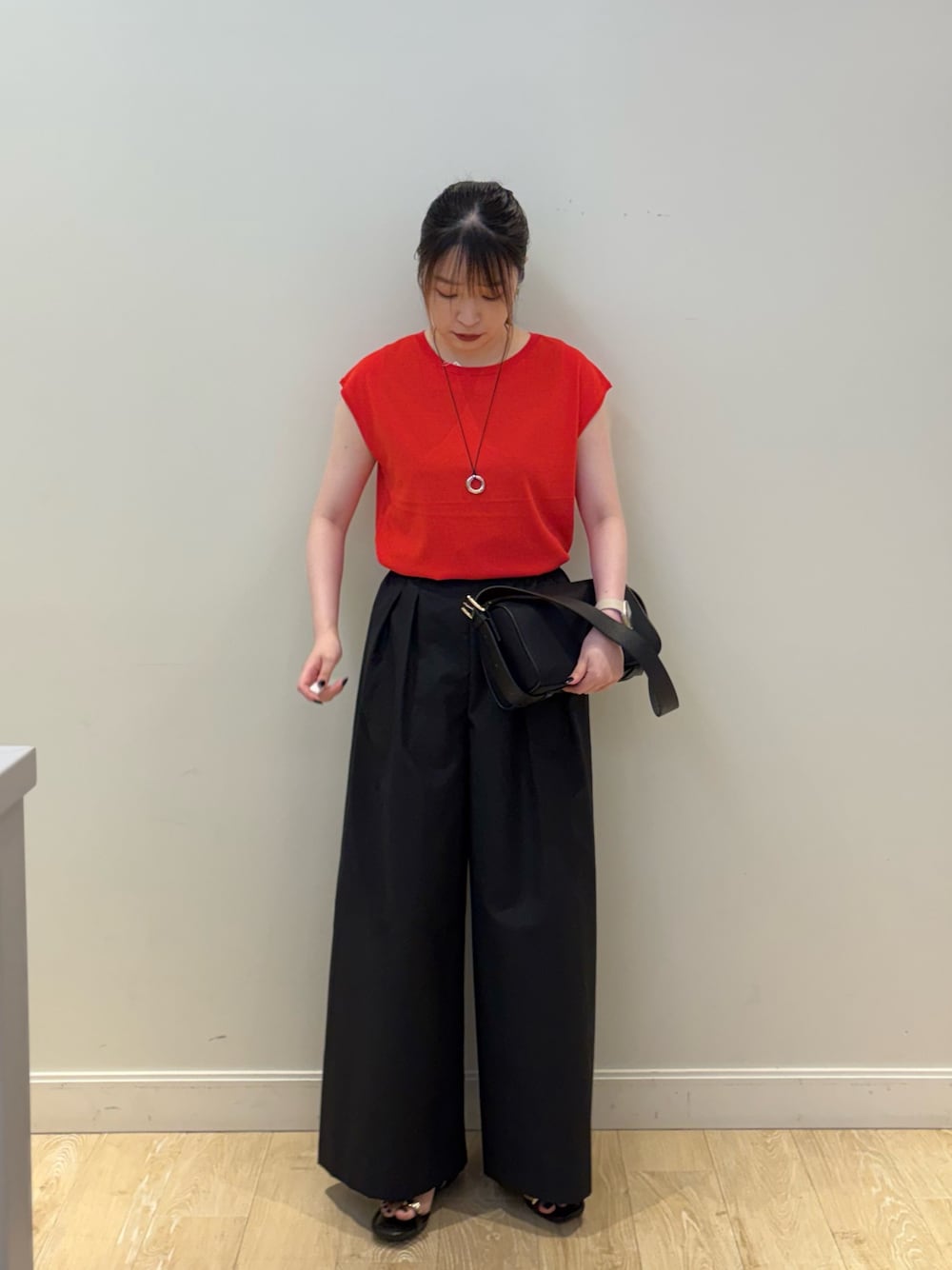 ブラック系のその他パンツ、ブラック系のショルダーバッグ、レッド系のニット/セーターを着用したレディースの夏コーディネートの1枚目の写真