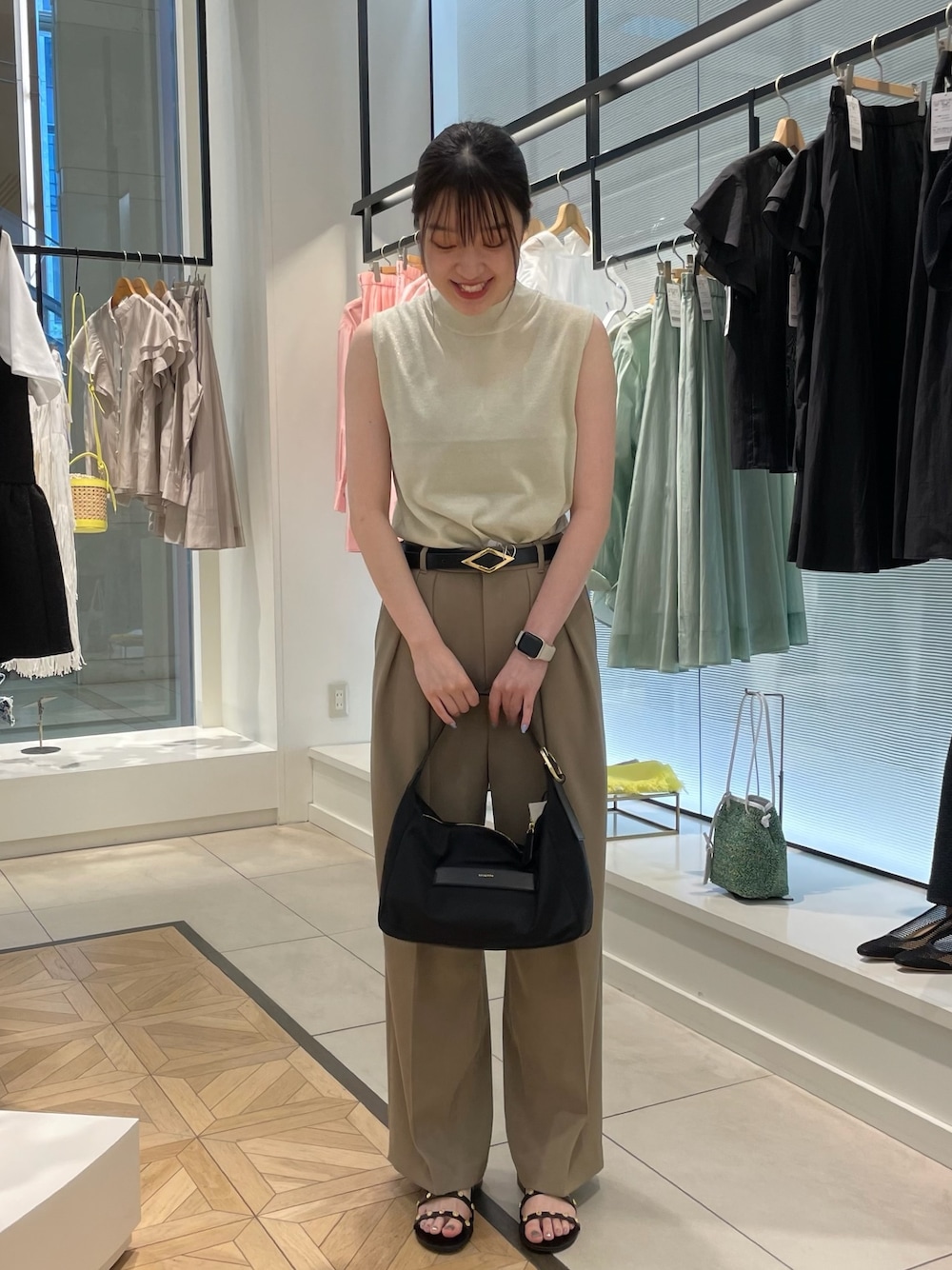 ゴールド系のニット/セーター、グリーン系のその他パンツ、ブラック系のショルダーバッグを着用したレディースの春コーディネートの1枚目の写真