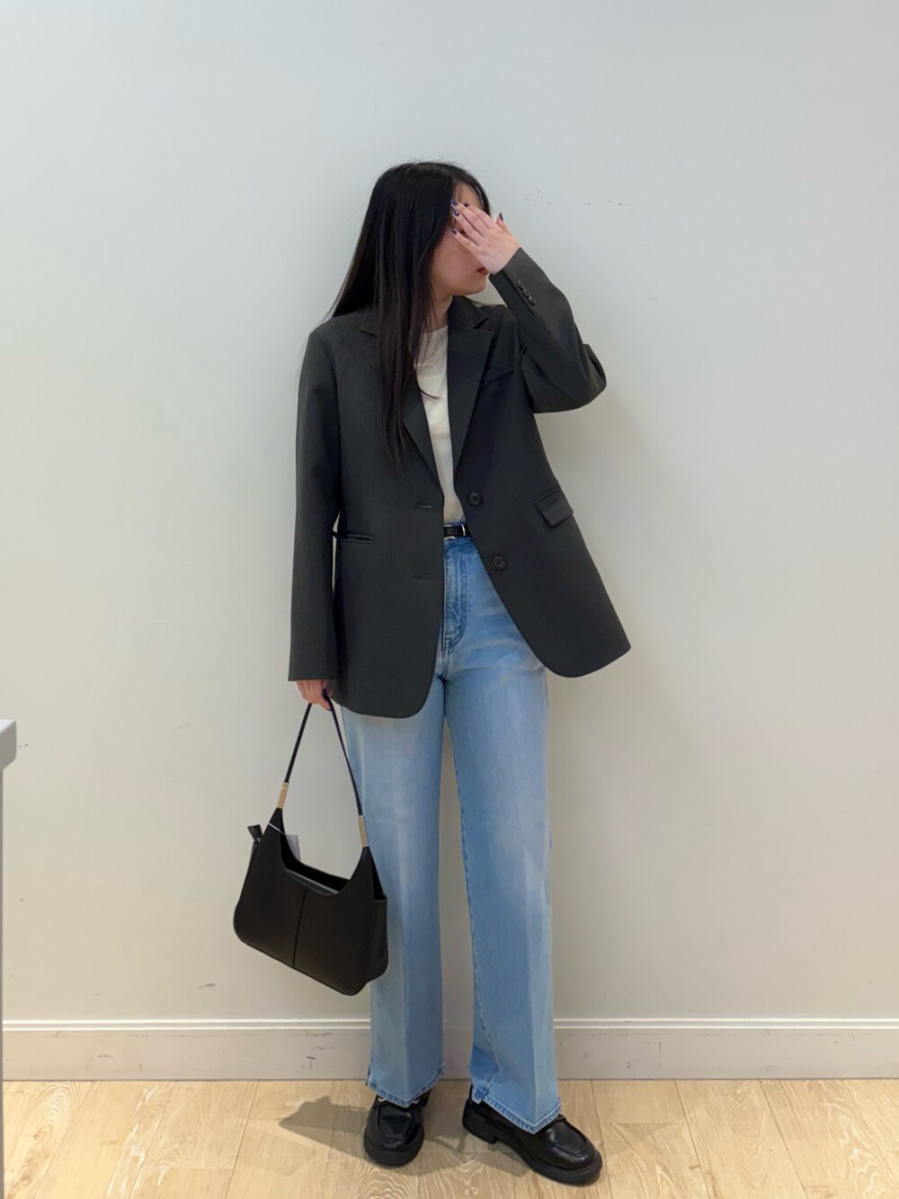 ブラック系のショルダーバッグ、ブルー系のデニムパンツ、ピンク系のTシャツ/カットソーを着用したレディースの秋コーディネートの1枚目の写真