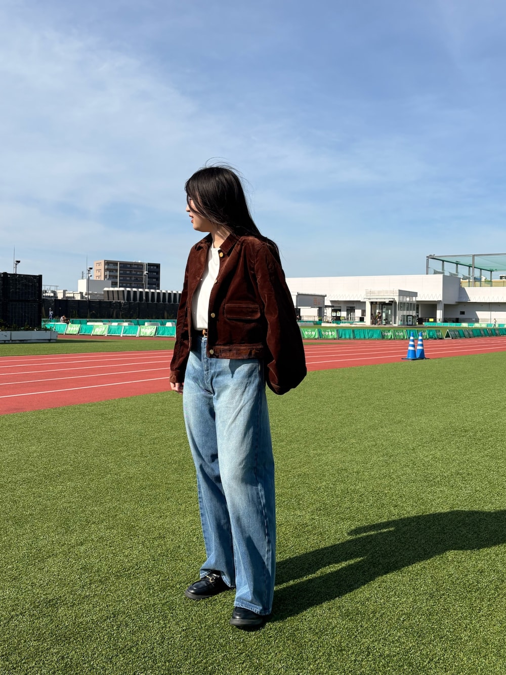 ブルー系のデニムパンツ、ホワイト系のTシャツ/カットソー、ブラウン系のブルゾンを着用したレディースの夏コーディネートの1枚目の写真