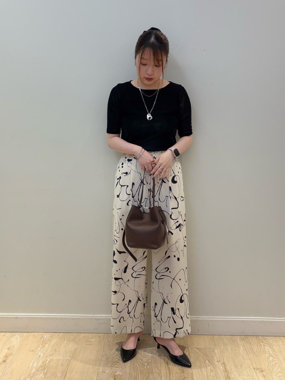 ブラウン系のショルダーバッグ、ホワイト系のその他パンツ、シルバー系のネックレスを着用したレディースの秋コーディネートの1枚目の写真