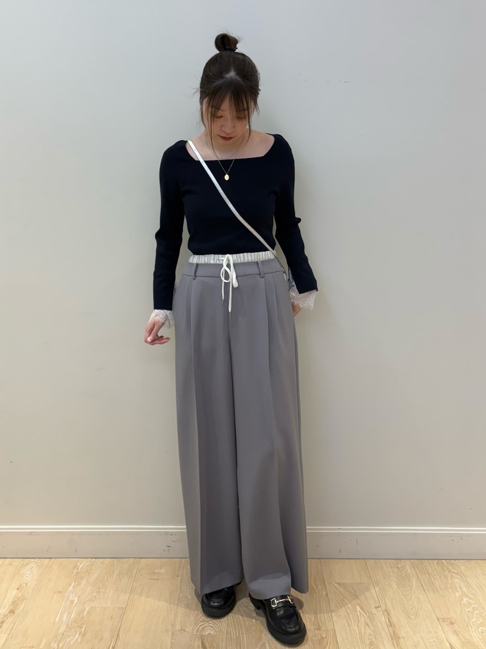 シルバー系のショルダーバッグ、ブルー系のニット/セーター、グレー系のその他パンツを着用したレディースの冬コーディネートの1枚目の写真