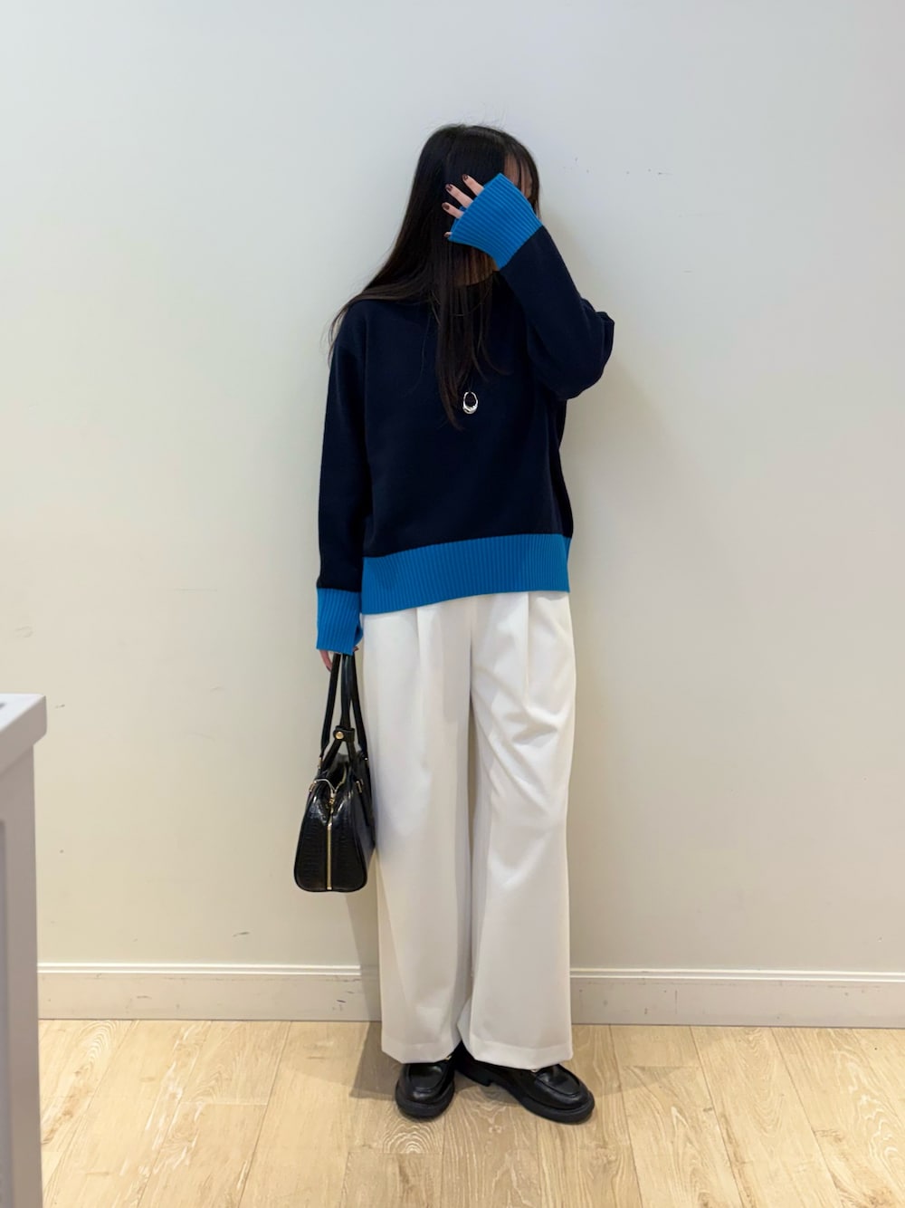 ブラック系のボストンバッグ、ホワイト系のその他パンツ、ブルー系のニット/セーターを着用したレディースの秋コーディネートの1枚目の写真