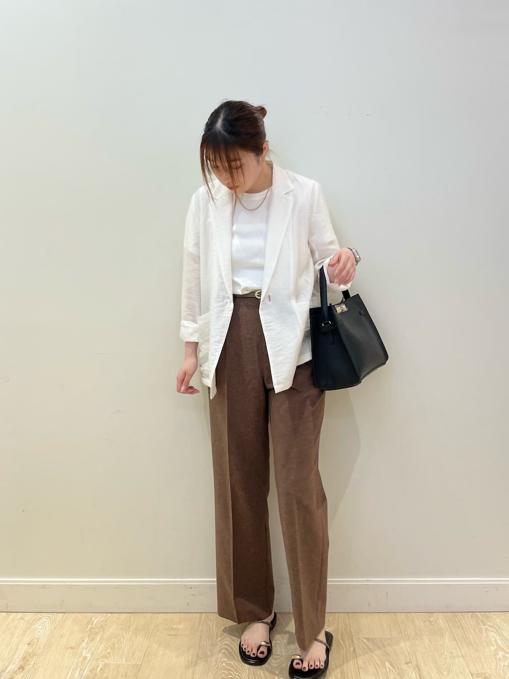 ブラック系のショルダーバッグ、グレー系のTシャツ/カットソー、ホワイト系のテーラードジャケットを着用したレディースの夏コーディネートの1枚目の写真