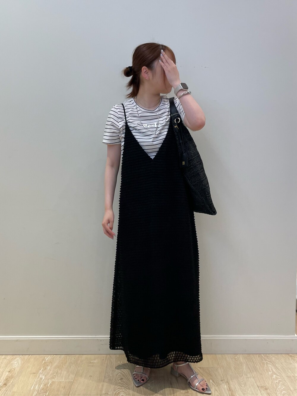 ブラック系のワンピース、ブラック系のショルダーバッグ、シルバー系のブレスレットを着用したレディースの夏コーディネートの1枚目の写真