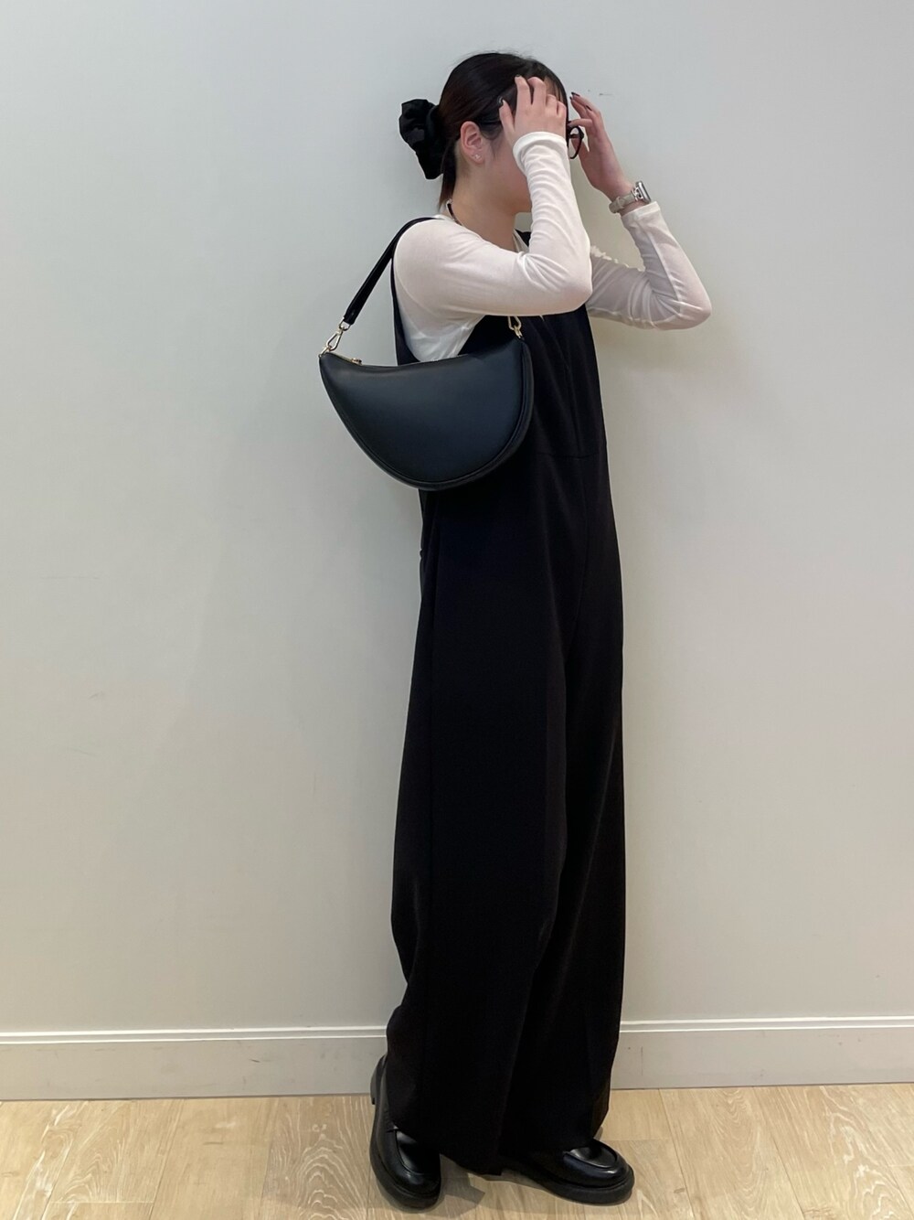 ブラック系のサロペット/オーバーオール、ブラック系のショルダーバッグ、ホワイト系のTシャツ/カットソーを着用したレディースの冬コーディネートの1枚目の写真