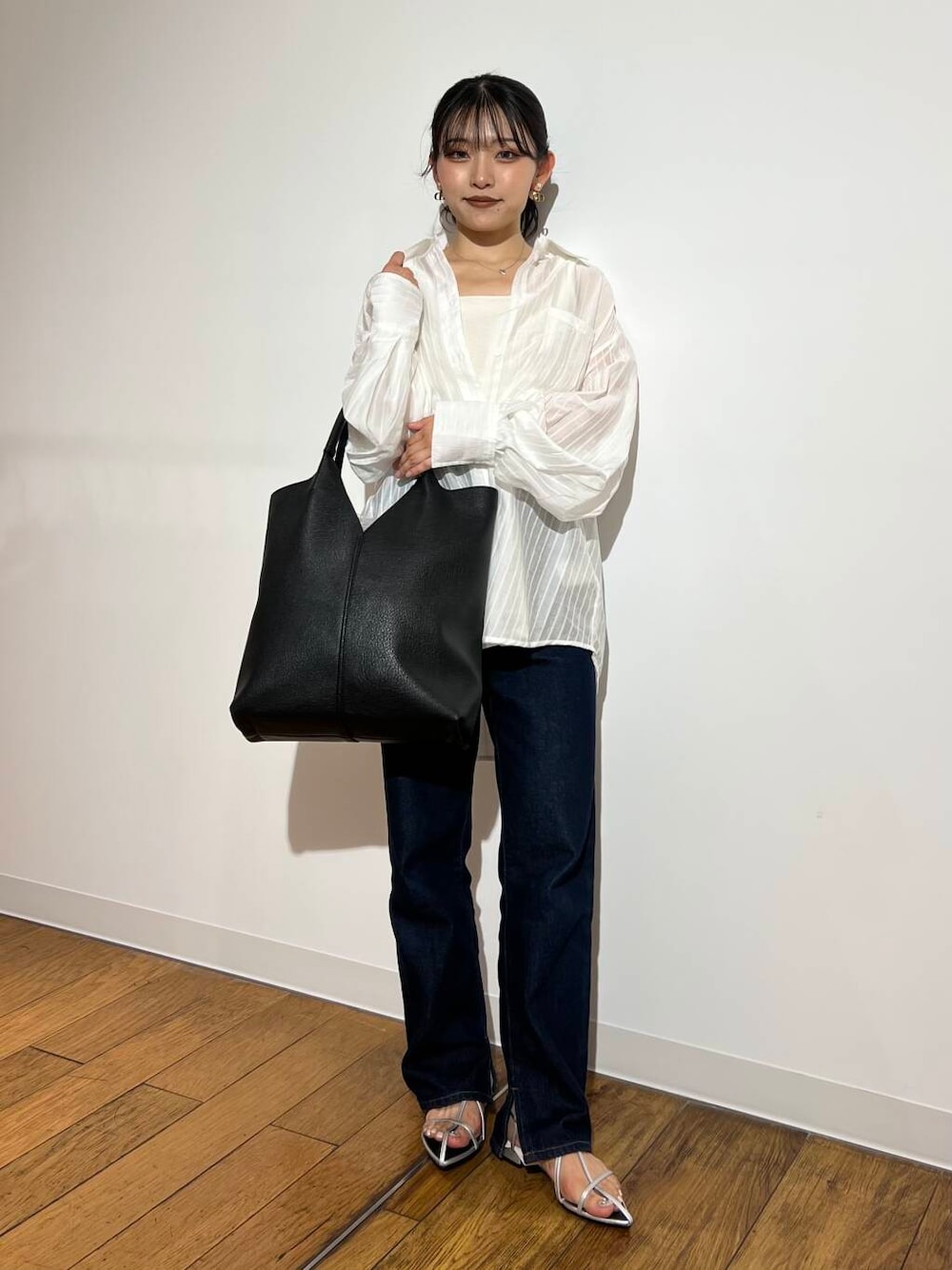 ブルー系のデニムパンツ、ホワイト系のシャツ/ブラウス、ブラック系のトートバッグを着用したレディースの夏コーディネートの1枚目の写真