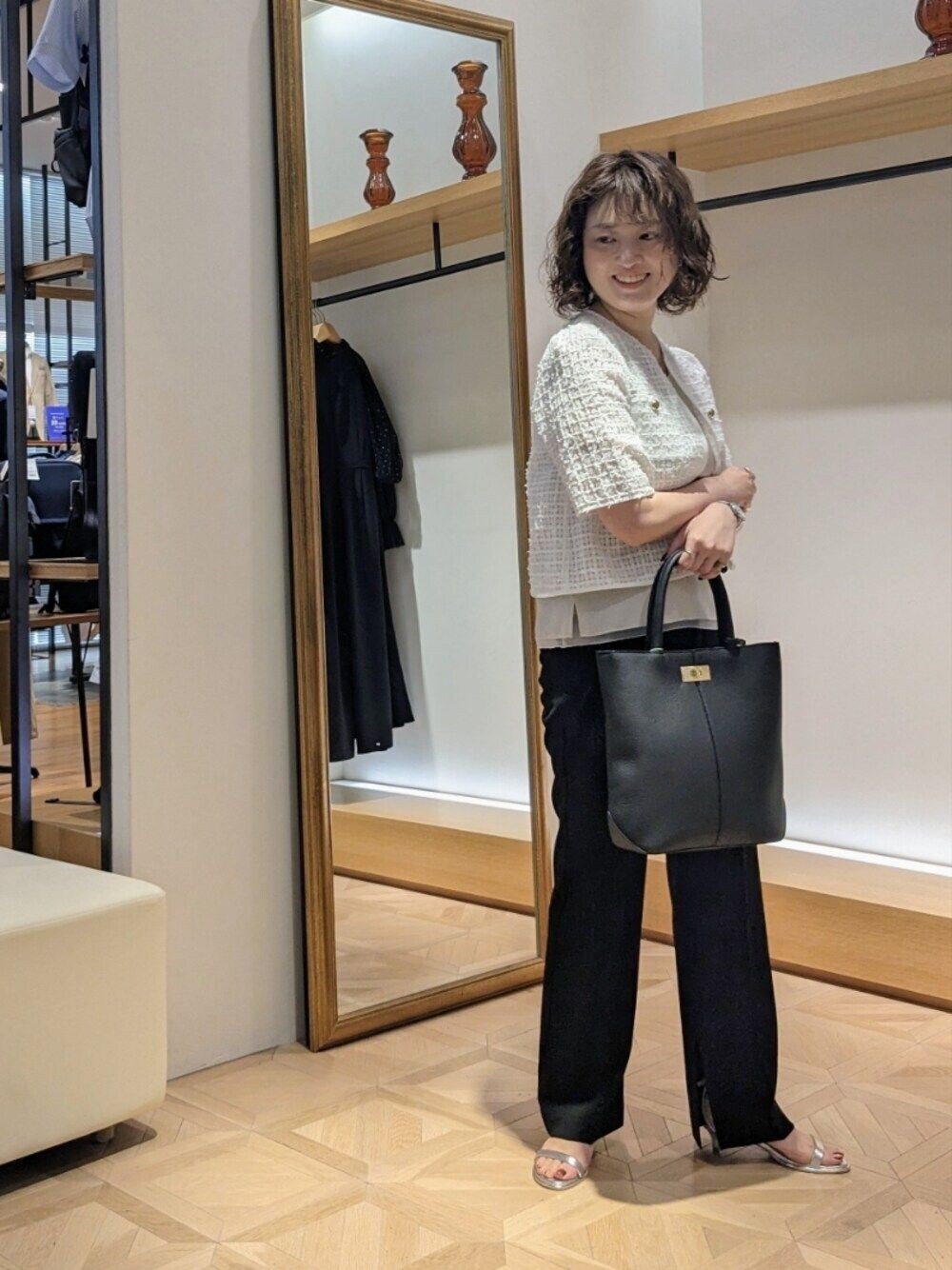 ホワイト系のノーカラージャケット、ブラック系のトートバッグ、ブラック系のその他パンツを着用したレディースの夏コーディネートの1枚目の写真