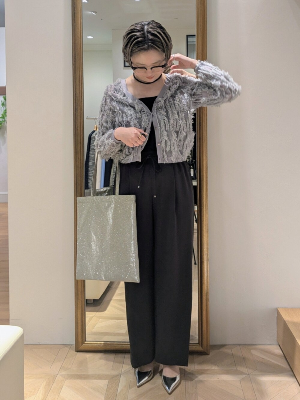 グレー系のその他パンツ、グレー系のカーディガン/ボレロ、ゴールド系のトートバッグを着用したレディースの春コーディネートの1枚目の写真