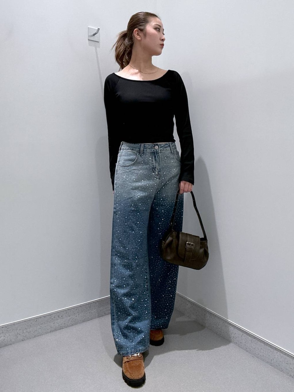 ブルー系のデニムパンツ、ブラウン系のローファー、ブラック系のTシャツ/カットソーを着用したレディースの冬コーディネートの1枚目の写真