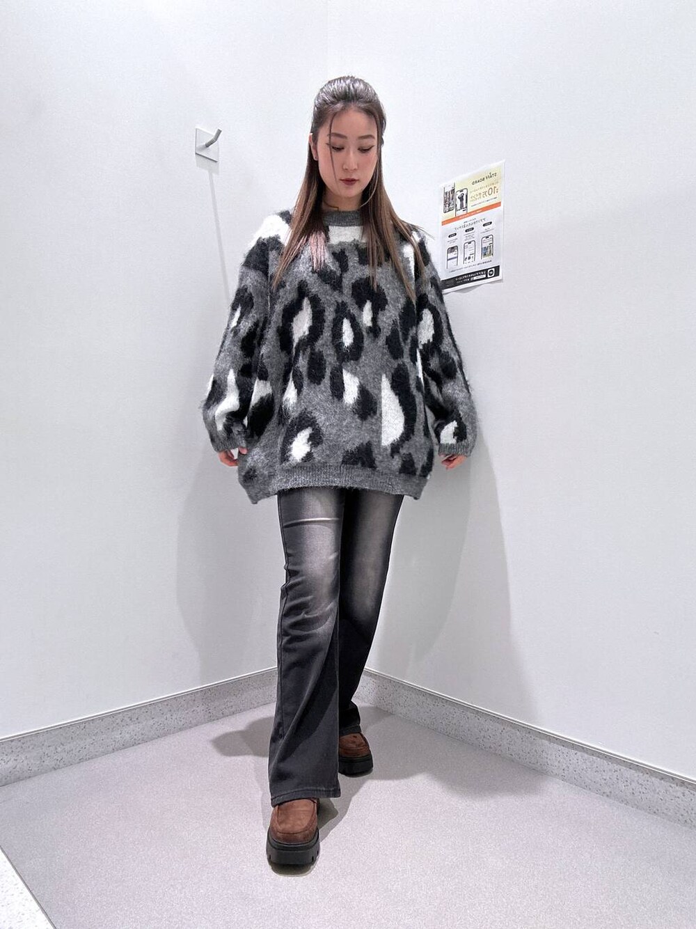 ブラウン系のローファー、ブラック系のデニムパンツ、グレー系のチュニックを着用したレディースの冬コーディネートの1枚目の写真
