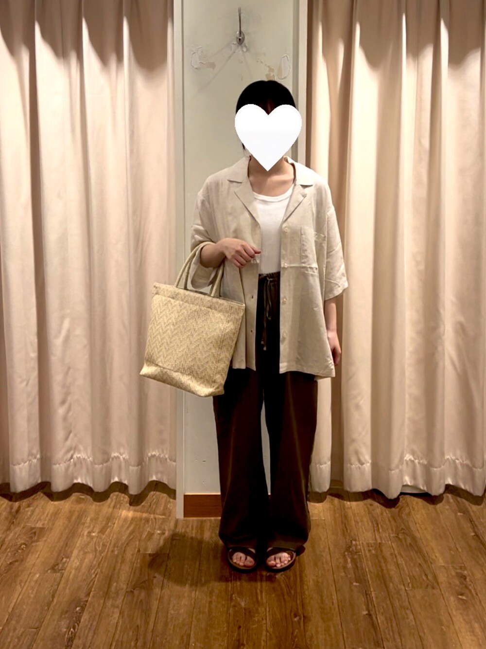ホワイト系のハンドバッグ、ホワイト系のタンクトップ、ブラウン系のパンツを着用したレディースの夏コーディネートの1枚目の写真