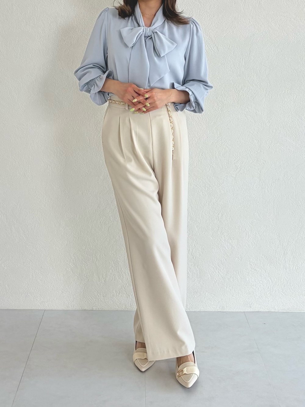 ブルー系のシャツ/ブラウス、ベージュ系のスラックスを着用したレディースの春コーディネートの1枚目の写真