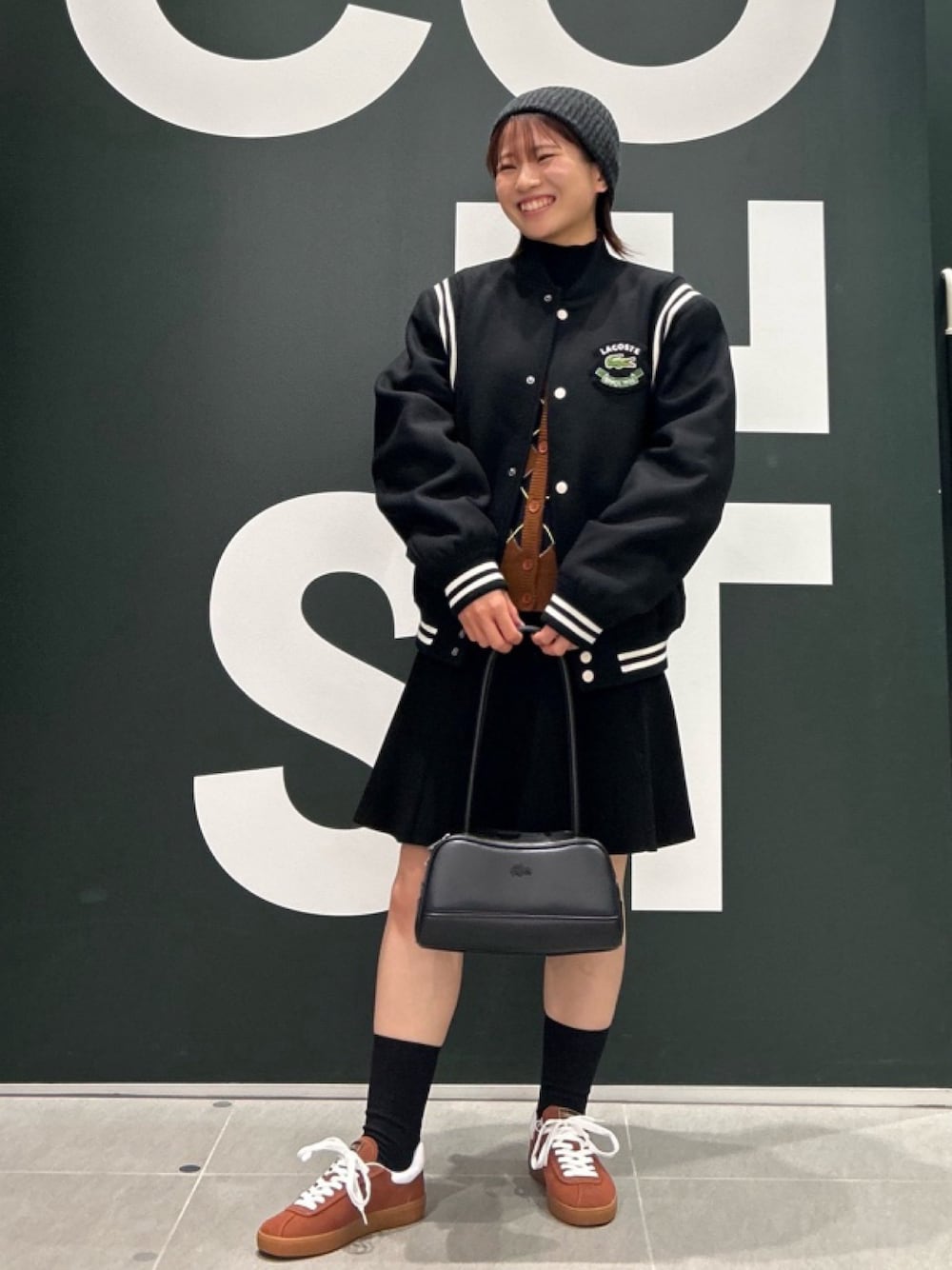 「レザーバッグ、ニットベスト、ニット帽、アウター」｜「LACOSTEのウールバーシティジャケット / 中綿ブルゾン（ブルゾン、ブラック系）」を使った、Uiさん（骨格ウェーブ・レディース・153cm）の春コーディネートの1枚目の写真