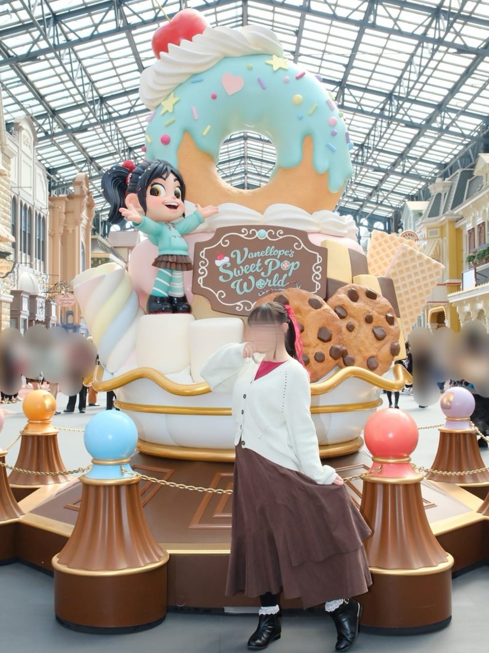 グリーン系のカーディガン/ボレロ、ピンク系のニット/セーター、ブラック系のブーツを着用したレディースの秋コーディネートの1枚目の写真