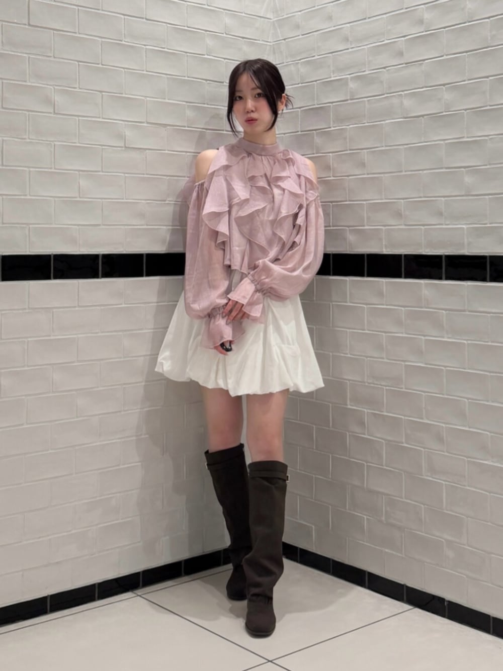 ピンク系のシャツ/ブラウス、ホワイト系のスカート、ブラウン系のブーツを着用したレディースの秋コーディネートの1枚目の写真