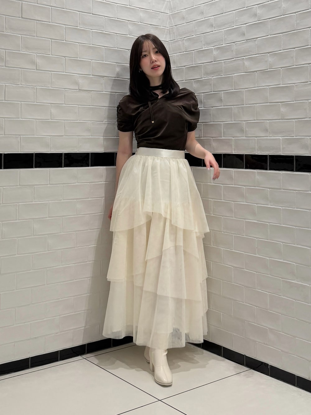 ブラウン系のTシャツ/カットソー、ホワイト系のスカート、ホワイト系のブーツを着用したレディースの秋コーディネートの1枚目の写真