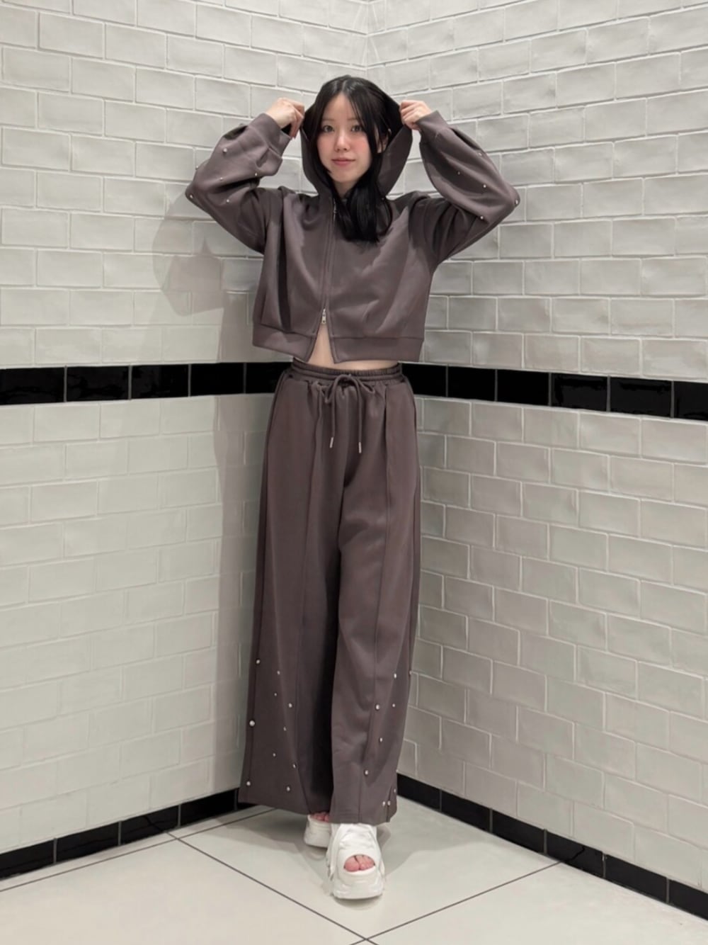 ブラウン系のTシャツ/カットソー、ブラウン系のスウェットパンツ、ホワイト系のサンダルを着用したレディースの夏コーディネートの1枚目の写真