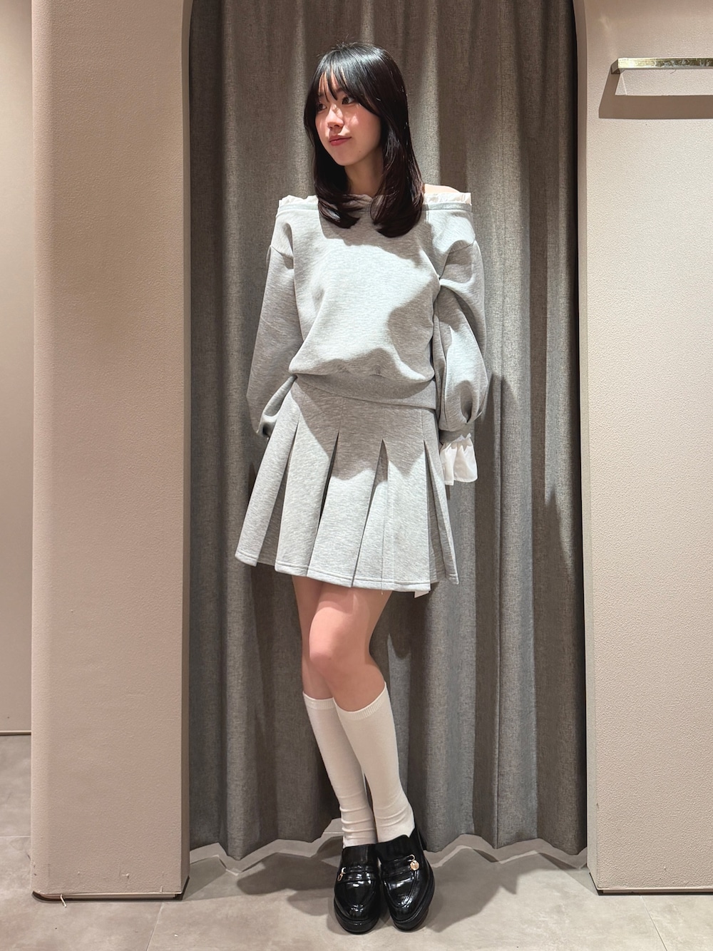 グレー系のTシャツ/カットソー、グレー系のスカート、ブラック系のパンプスを着用したレディースの春コーディネートの1枚目の写真