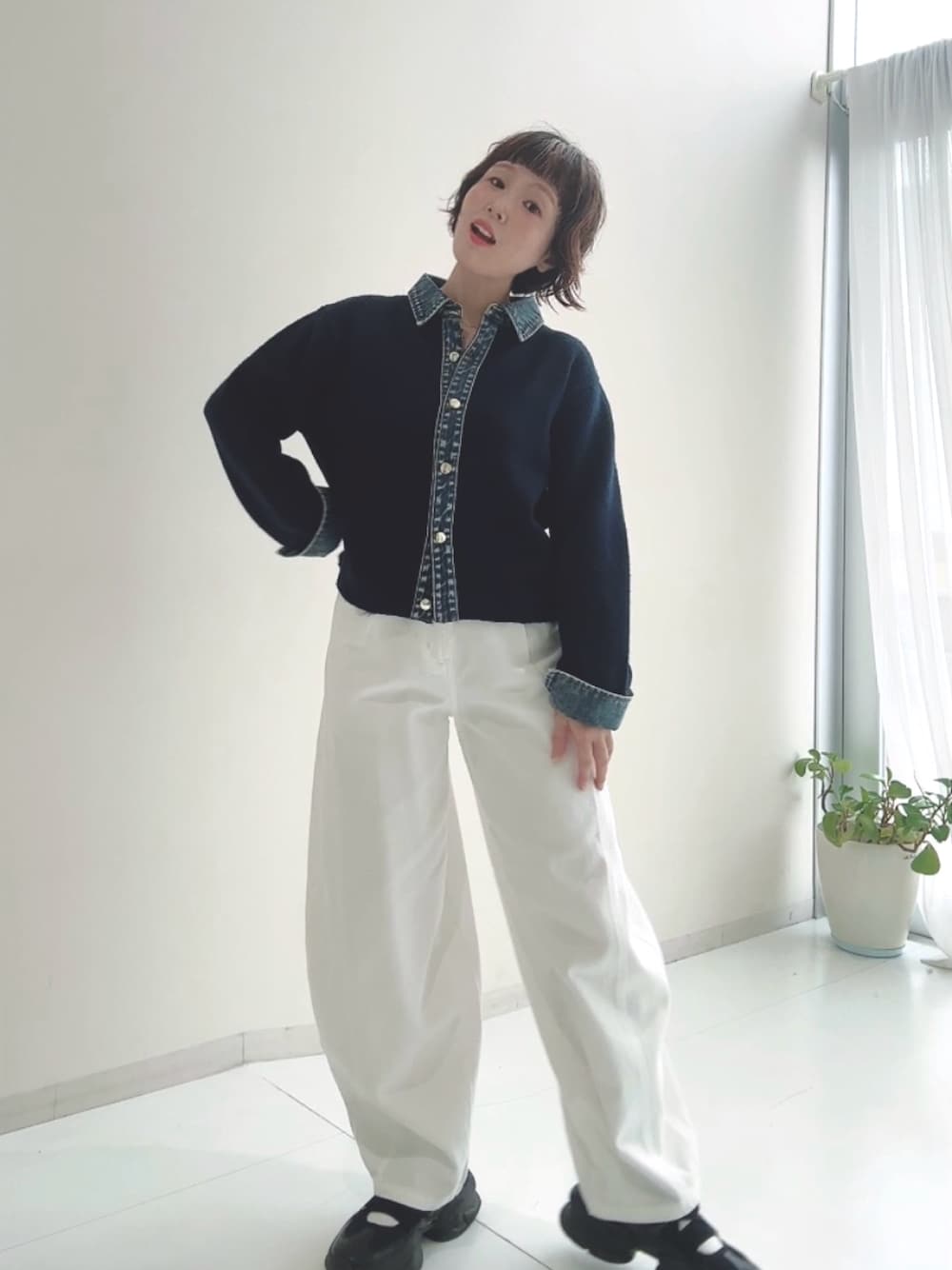 グレー系のニット/セーター、ブルー系のパンツを着用したレディースの秋コーディネートの1枚目の写真