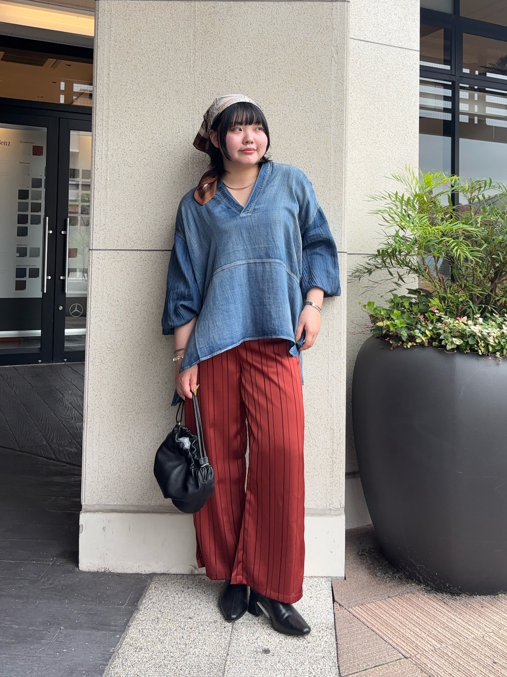 ブラック系のトートバッグ、オレンジ系のその他パンツ、ブルー系のシャツ/ブラウスを着用したレディースの秋コーディネートの1枚目の写真
