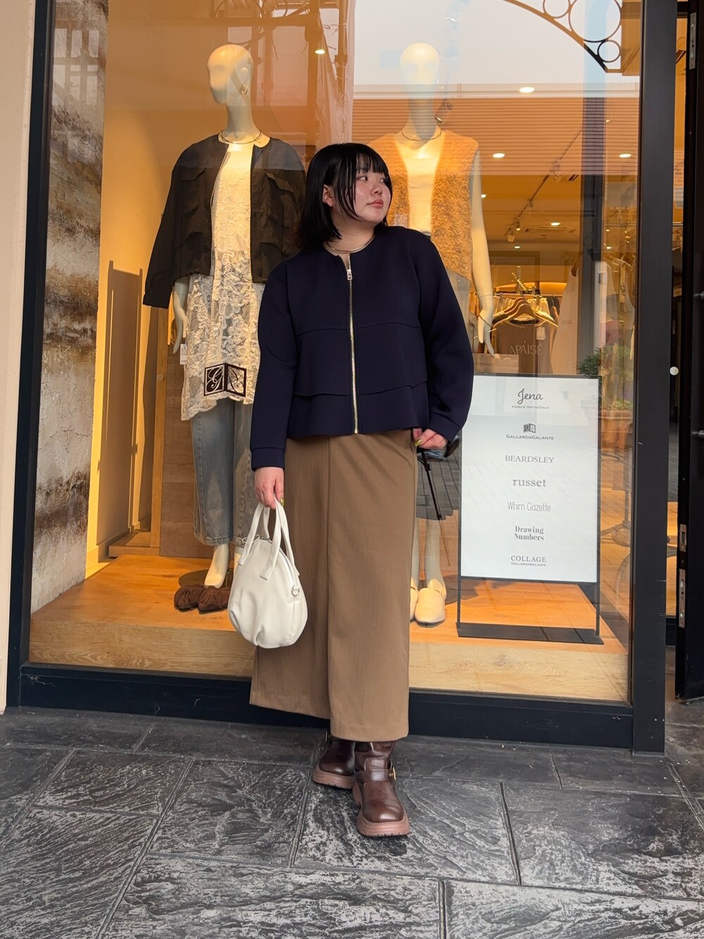 ブルー系のTシャツ/カットソー、ブラウン系のスカート、ホワイト系のトートバッグを着用したレディースの秋コーディネートの1枚目の写真