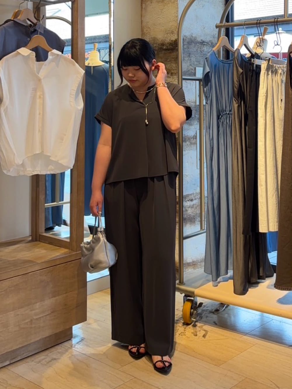 グレー系のワンピース、シルバー系のトートバッグ、シルバー系のリングを着用したレディースの春コーディネートの1枚目の写真