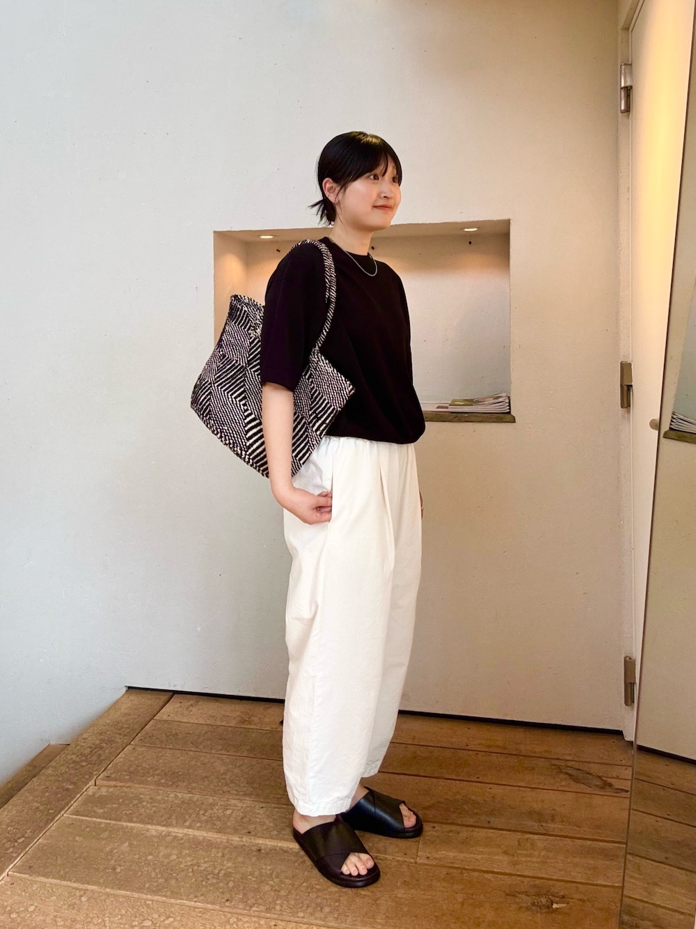 ホワイト系のその他パンツ、ブラック系のサンダル、ブラック系のニット/セーターを着用したレディースの夏コーディネートの1枚目の写真